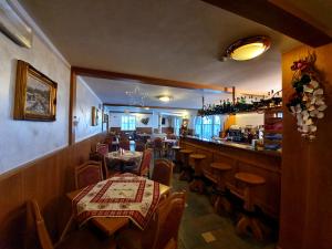 a restaurant with tables and chairs and a bar at Hotel Panorama in Passo del Tonale