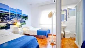 a hotel room with two beds and a sink at Casa Reyes El Palmar in El Palmar