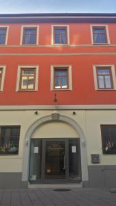 a red building with an archway in front of it at Boutique-Hotel Kronenstuben in Ludwigsburg