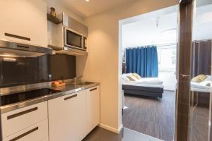 een keuken met een wastafel en een kamer met een bed bij Svartisen Apartments in Glomfjord