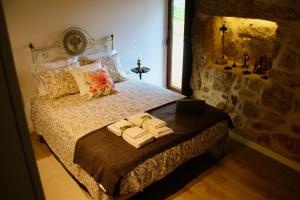 une chambre avec un lit avec deux serviettes dessus dans l'établissement Casa da Mina - Eido do Pomar, à Arcos de Valdevez