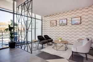 a living room with two chairs and a table at Lemon Tree Hotel, Jumeirah Dubai in Dubai