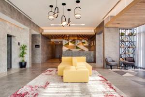 a living room with a yellow couch and a rug at Lemon Tree Hotel, Jumeirah Dubai in Dubai
