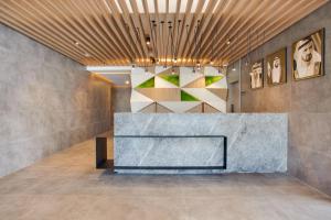 a lobby with a concrete counter and paintings on the wall at Lemon Tree Hotel, Jumeirah Dubai in Dubai