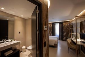 a bathroom with a sink and a bed and a mirror at Hotel Pateo - Lisbon Lounge Suites in Lisbon