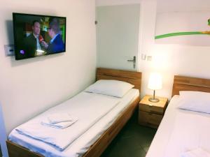 dwa łóżka w pokoju z telewizorem na ścianie w obiekcie AJO Apartments - Alte Donau Terrace Studio - Self-Check-in w Wiedniu +4 zdjęcia