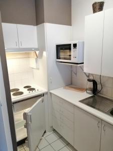 a kitchen with white cabinets and a microwave at Value stay in apartment 100m from beach promenade in Blankenberge