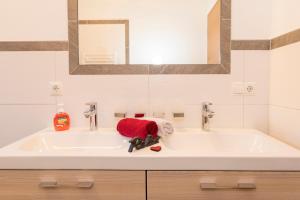 a bathroom sink with a red towel on it at Appartement Hausberger in Alpbach