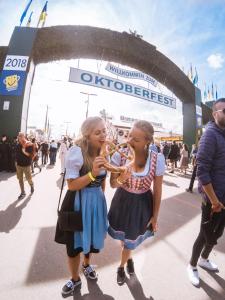 two girls playing a brass instrument in front of a stadium at Oktoberfest on a Budget Munich in Munich