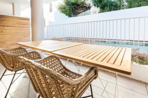 une table en bois et quatre chaises sur la terrasse dans l'établissement Les jardins secrets, à Antibes