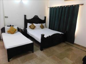 two beds in a room with black and white at AB Guesthouse in Rawalpindi