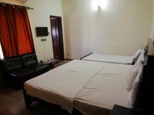 a hotel room with two beds and a chair at AB Guesthouse in Rawalpindi +3 photos