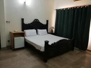 a bedroom with a large black bed with black curtains at AB Guesthouse in Rawalpindi