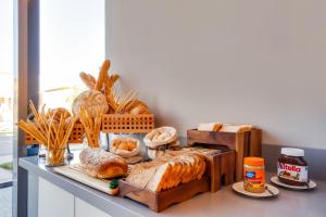 a counter with various types of bread and pastries at Lemon Tree Hotel, Jumeirah Dubai in Dubai