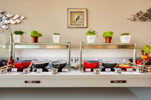 a counter with bowls and pans on a shelf at Lemon Tree Hotel, Jumeirah Dubai in Dubai