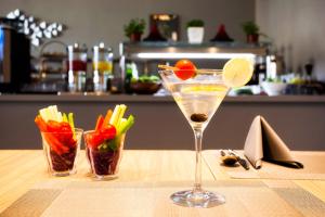 a martini glass with a lemon and vegetables on a table at Lemon Tree Hotel, Jumeirah Dubai in Dubai