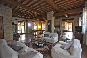 sala de estar con sofás blancos y TV en Villa Monica, en San Costanzo
