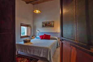 a bedroom with a bed with red pillows on it at Appartamento Loretello in Arcevia
