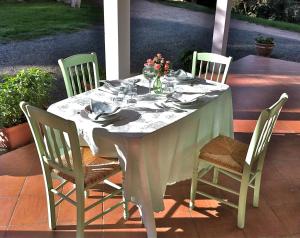 a table with chairs and a white table cloth on it at Agriturismo Campo Al Sole in Castell’Anselmo
