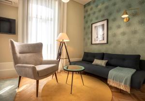 uma sala de estar com um sofá e uma cadeira em Harbour Inn Design Townhouse em Matosinhos