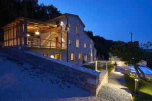 a large house with a stone wall at night at Appartamento Nidastore in Arcevia