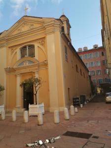 尼斯的住宿－2 pièces Vieux-Nice N，前面有一棵树的黄色教堂