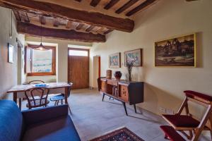 ein Wohnzimmer mit einem Tisch und einem Schreibtisch in der Unterkunft Appartamento Piticchio in Arcevia