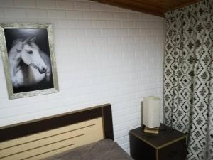 a bedroom with a painting of a horse on the wall at Manoni Ratiani's Guesthouse in Mestia