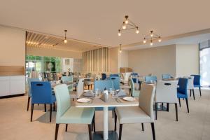 a dining room with tables and blue chairs at Lemon Tree Hotel, Jumeirah Dubai in Dubai