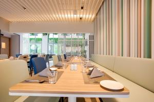 a long dining room with a long table and chairs at Lemon Tree Hotel, Jumeirah Dubai in Dubai