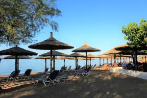 a group of chairs and umbrellas on a beach at Luxe Villa Livadia, 10 personen in Kandia