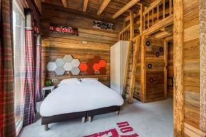 ティーニュにあるChalet Carte Blanche Rock N' Loveの木造キャビン内のベッド1台が備わるベッドルーム1室を利用します。