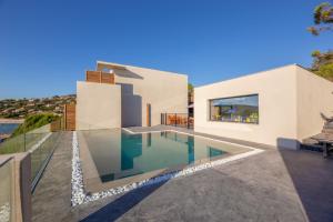 a house with a swimming pool in front of it at Hotel le Jardin d'Emile in Porticcio