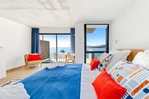 a bedroom with a large bed with colorful pillows at Hotel le Jardin d'Emile in Porticcio