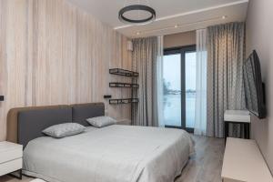 a bedroom with a large bed and a large window at Riviera Zoloche Resort & Spa in Vishenki