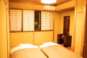 Tempat tidur dalam kamar di 泊まれる図書館 寄処 -yosuga-