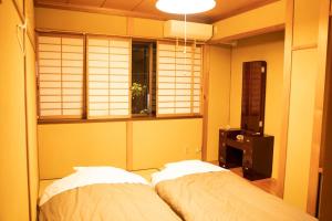 富山市にある泊まれる図書館 寄処 -yosuga-のベッドルーム1室(ベッド2台、窓、シャッター付) +37枚の写真