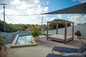a swimming pool with a gazebo next to a swimming pool at Sunny Hill Apartment in Willemstad
