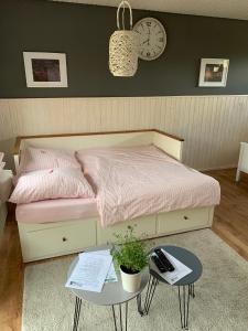 ein Schlafzimmer mit einem Bett, einem Tisch und einer Uhr in der Unterkunft Gemütliche Heide-Ferienwohnung in Soltau