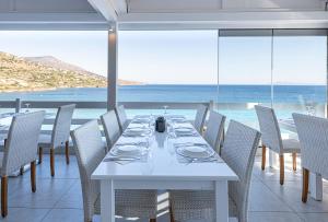 a dining room with a white table and chairs at Hotel Perrakis in Kipri