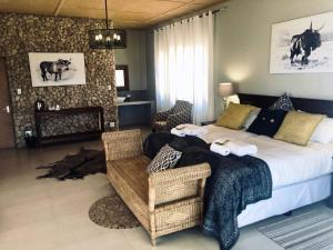 ein Schlafzimmer mit einem großen Bett und einem Stuhl in der Unterkunft Burgsdorf Guest Farm in Maltahöhe