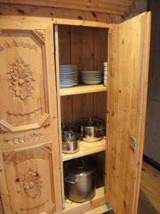 a wooden cabinet with pots and pans in it at Trudis Hoamat in Bach