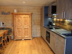 eine Küche mit Holzschränken und einem Holztisch in der Unterkunft Trudis Hoamat in Bach