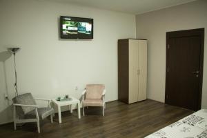 a room with two chairs and a table and a tv at Alex Lodge in Zrenjanin