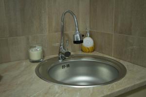 a sink with a faucet and a glass of milk at Alex Lodge in Zrenjanin