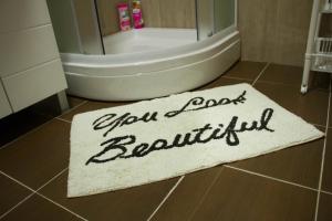 a bathroom with a bath tub and a rug on the floor at Alex Lodge in Zrenjanin