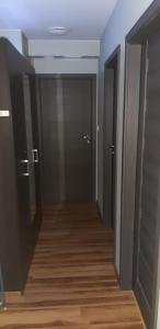 pusty korytarz z dwoma drzwiami i drewnianą podłogą w obiekcie Hostel Tip Top w Gdańsku