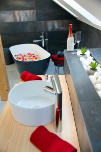 um balcão de cozinha com um lavatório e uma banheira com copos de vinho em Elvíra ubytování v soukromém em Kutná Hora