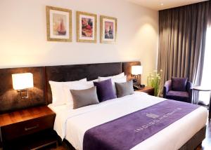 ラホールにあるIndigo Heights Hotel & Suitesの大型ベッド1台とランプ2つが備わるホテルルームです。 +37枚の写真