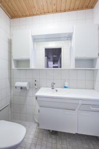 a white bathroom with a sink and a mirror at Holiday Club Punkaharju Cottages in Kulennoinen